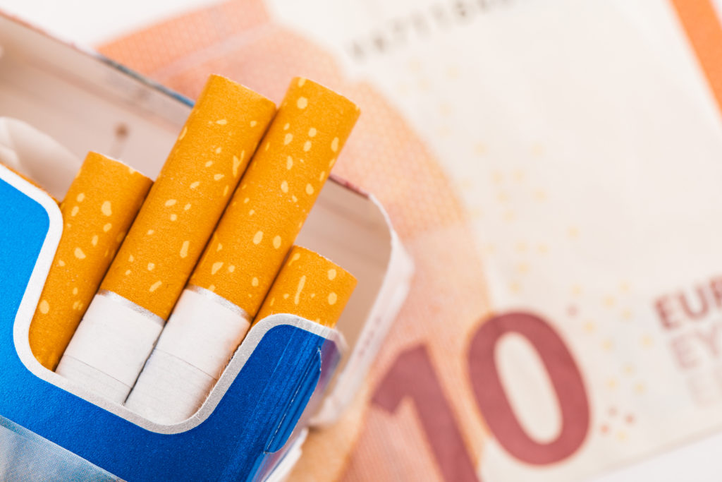 open pack cigarettes with yellow filter background euro banknotes 1024x683 - Cena auta. Aj o toľko môžu obézni fajčiari preplatiť životné poistenie